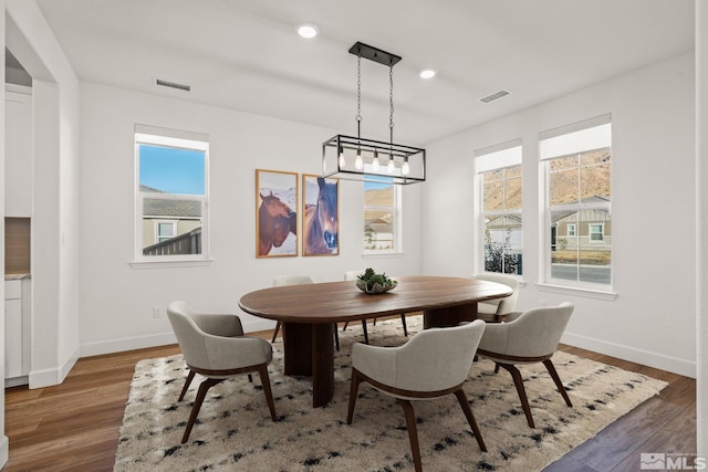 dining room featuring a wealth of natural light, dark hardwood / wood-style floors, and a notable chandelier