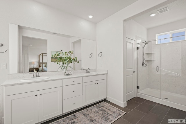 bathroom with an enclosed shower, vanity, and tile patterned flooring