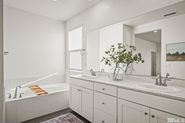 bathroom featuring a tub to relax in, vanity, and tile patterned floors