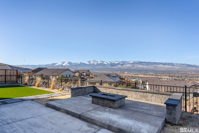 view of patio / terrace with a mountain view and a fire pit