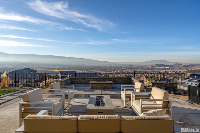 view of patio / terrace featuring a mountain view, area for grilling, and an outdoor living space with a fire pit