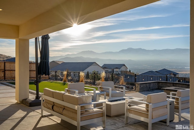 view of patio with an outdoor living space with a fire pit and a mountain view