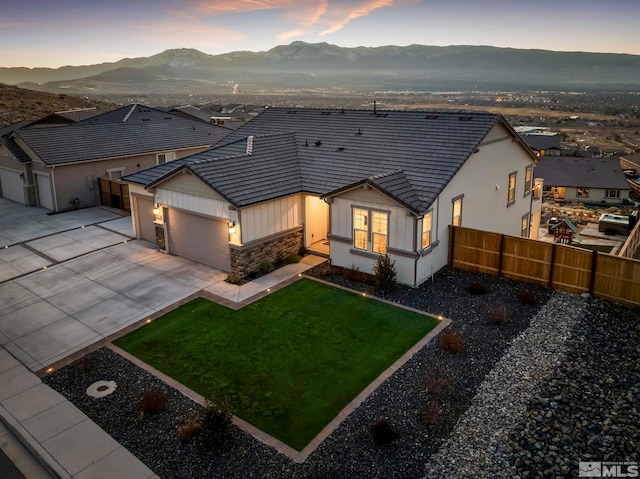 view of front of property with a lawn, a mountain view, and a garage