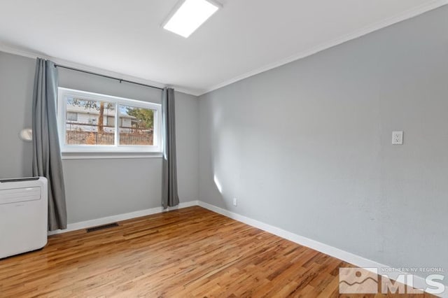 spare room featuring light hardwood / wood-style flooring and ornamental molding