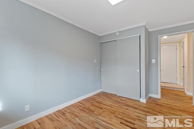 unfurnished bedroom with a closet, crown molding, and hardwood / wood-style flooring