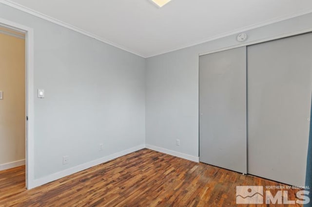 unfurnished bedroom with a closet, dark hardwood / wood-style flooring, and ornamental molding