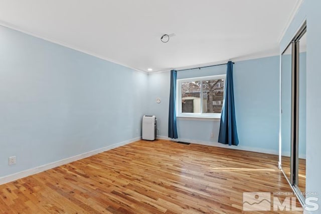 unfurnished room with ornamental molding and hardwood / wood-style floors