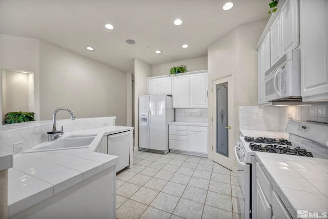 kitchen featuring white cabinetry, white appliances, and tile countertops