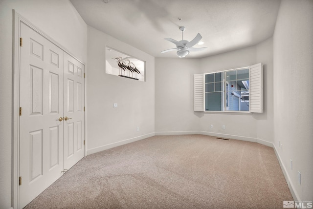 carpeted empty room with ceiling fan