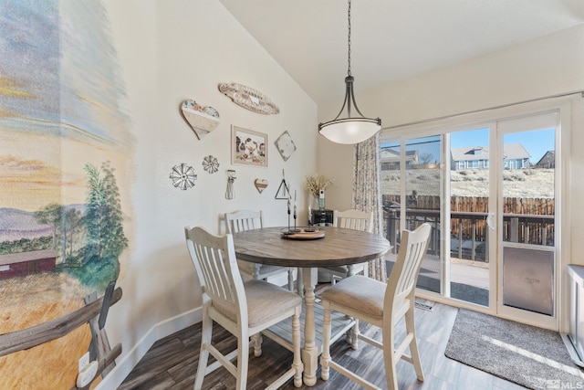 dining area with lofted ceiling and hardwood / wood-style floors