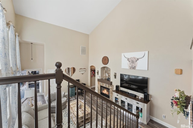 staircase with vaulted ceiling, a fireplace, and wood-type flooring