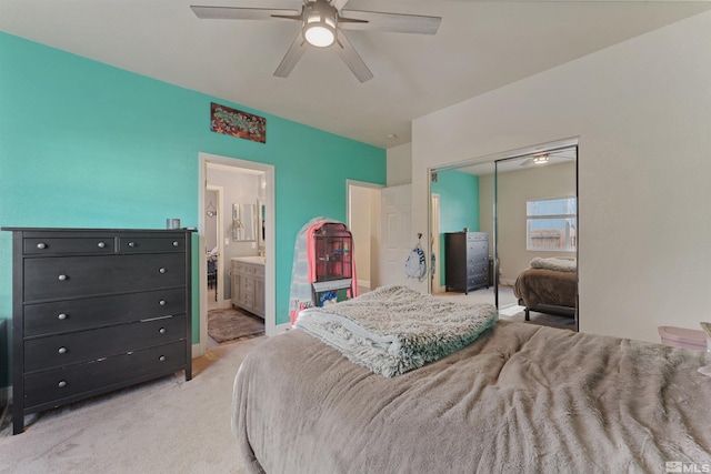 bedroom with light carpet, a closet, ensuite bath, and ceiling fan