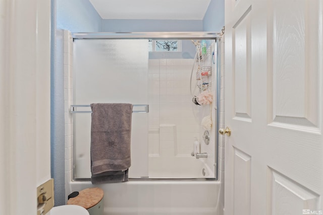 bathroom featuring shower / bath combination with glass door and toilet