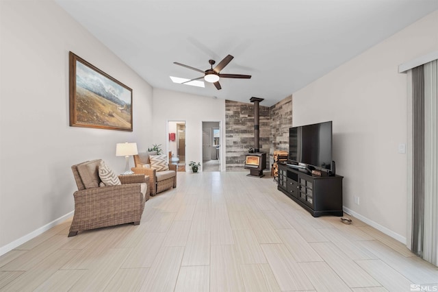 living room with ceiling fan, lofted ceiling, and a wood stove