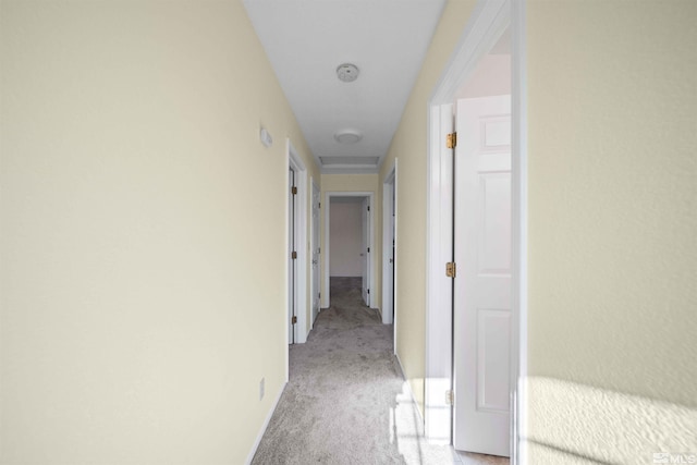 hallway featuring light colored carpet