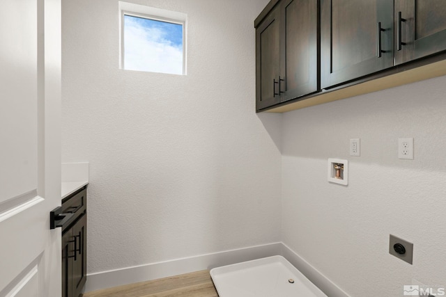 clothes washing area featuring washer hookup, cabinets, light wood-type flooring, and electric dryer hookup