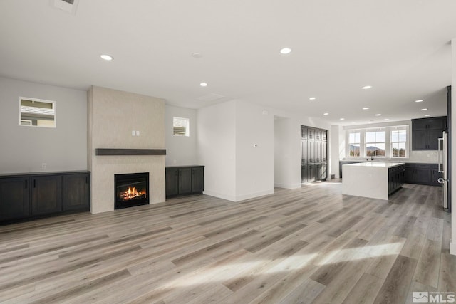 unfurnished living room featuring light wood-type flooring and a fireplace