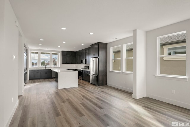 kitchen with light hardwood / wood-style flooring, appliances with stainless steel finishes, and a center island