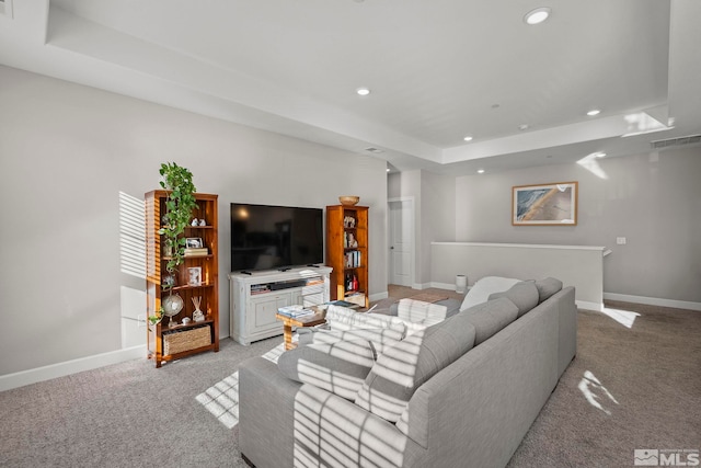 carpeted living room with a raised ceiling