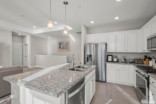 kitchen featuring pendant lighting, sink, white cabinetry, a kitchen island with sink, and appliances with stainless steel finishes