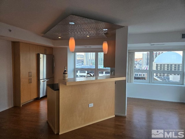 kitchen with dark hardwood / wood-style floors, kitchen peninsula, stainless steel fridge, and sink