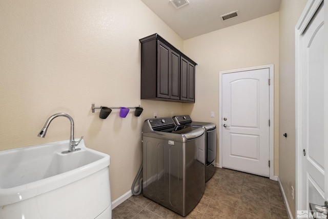 washroom featuring light tile patterned floors, cabinets, washer and dryer, and sink