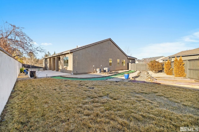 rear view of house with a lawn and a patio