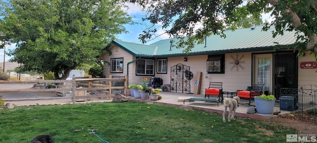 rear view of house with a lawn and a patio