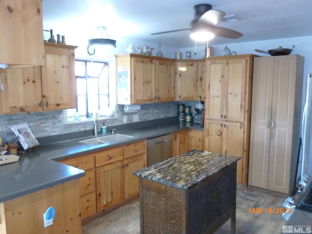 kitchen with a center island, sink, stainless steel dishwasher, and light brown cabinetry