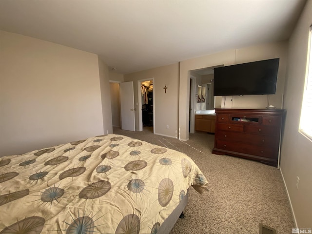 carpeted bedroom featuring a closet, a spacious closet, and connected bathroom