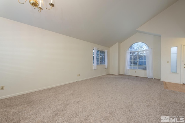 unfurnished living room with light colored carpet, vaulted ceiling, and a chandelier