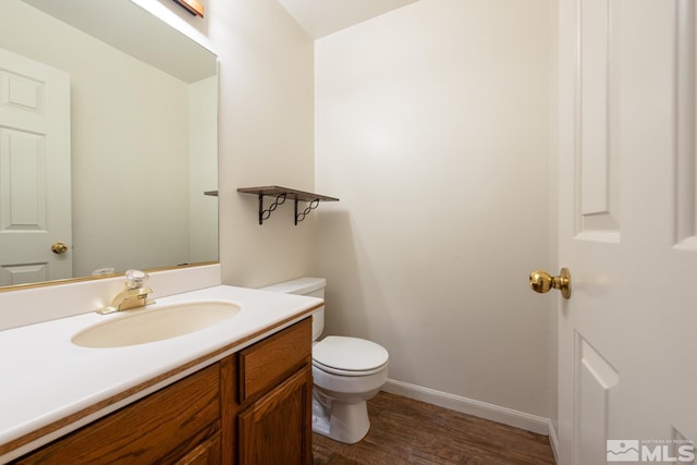 bathroom with hardwood / wood-style floors, toilet, and vanity