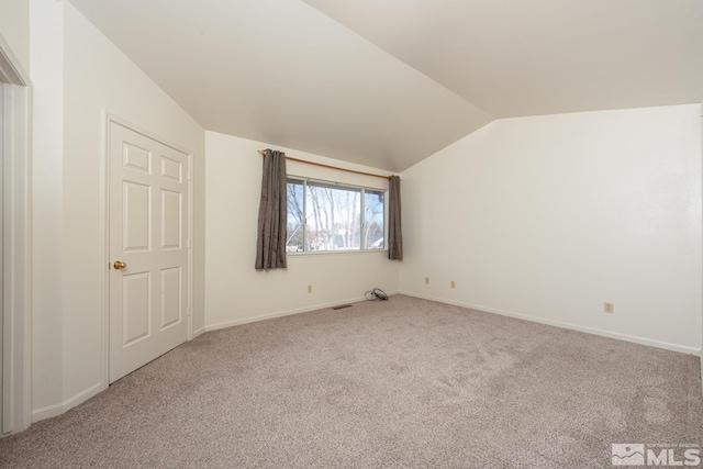 additional living space featuring carpet and vaulted ceiling