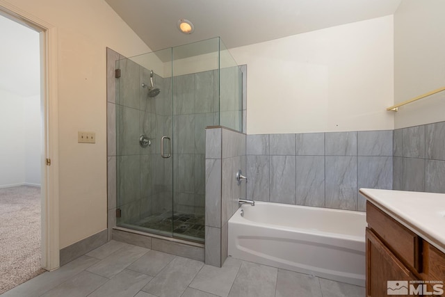 bathroom featuring vanity, vaulted ceiling, tile patterned floors, and shower with separate bathtub