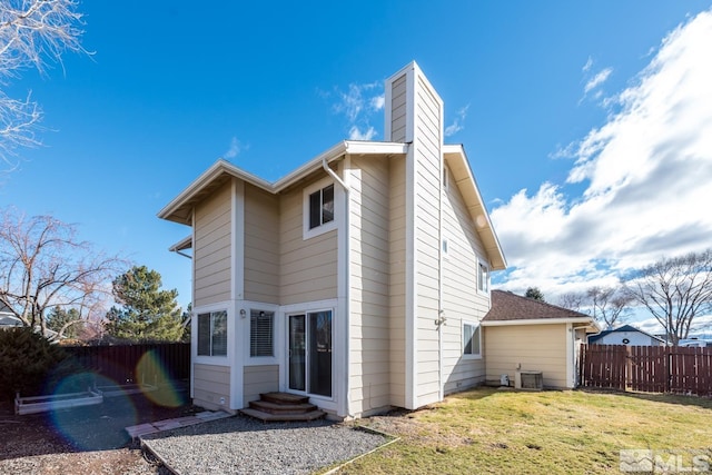 back of house with central AC and a yard