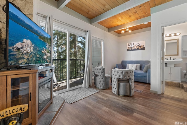 living room featuring beam ceiling, sink, hardwood / wood-style flooring, wood ceiling, and a chandelier