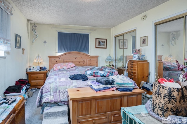 bedroom featuring multiple closets and a textured ceiling