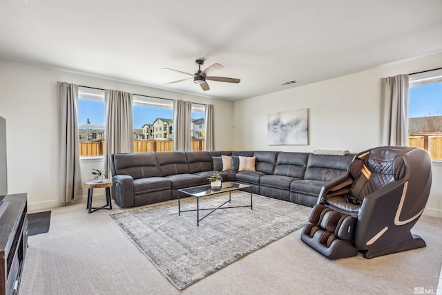 carpeted living area featuring baseboards, visible vents, and a ceiling fan