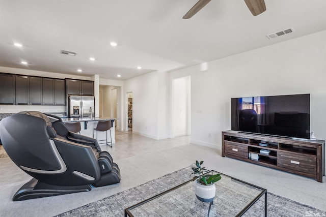 living room with ceiling fan, visible vents, and recessed lighting