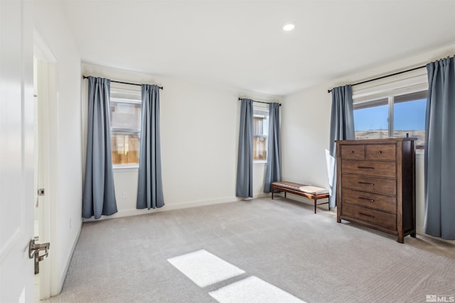 unfurnished bedroom featuring carpet floors, multiple windows, baseboards, and recessed lighting