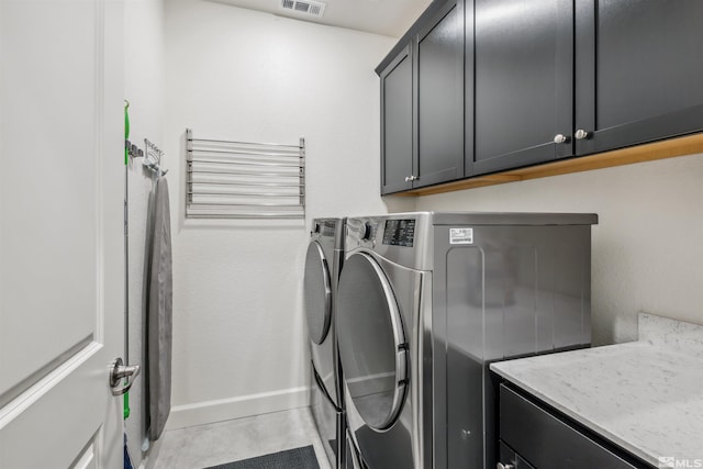 clothes washing area featuring visible vents, independent washer and dryer, cabinet space, and baseboards