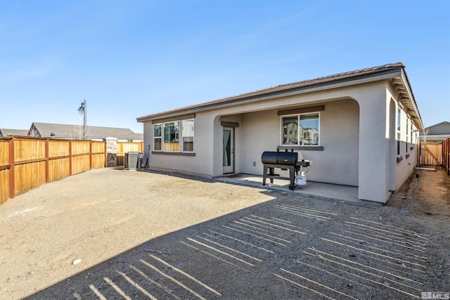 back of property featuring central AC, a patio area, fence, and stucco siding