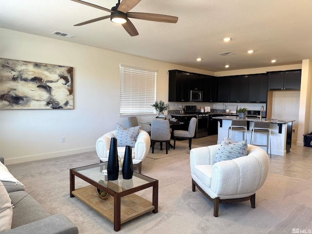 living area featuring baseboards, visible vents, and recessed lighting