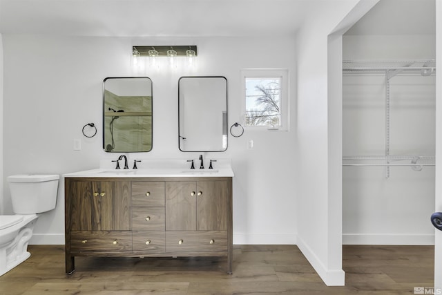 bathroom with toilet, a shower with door, hardwood / wood-style floors, and vanity