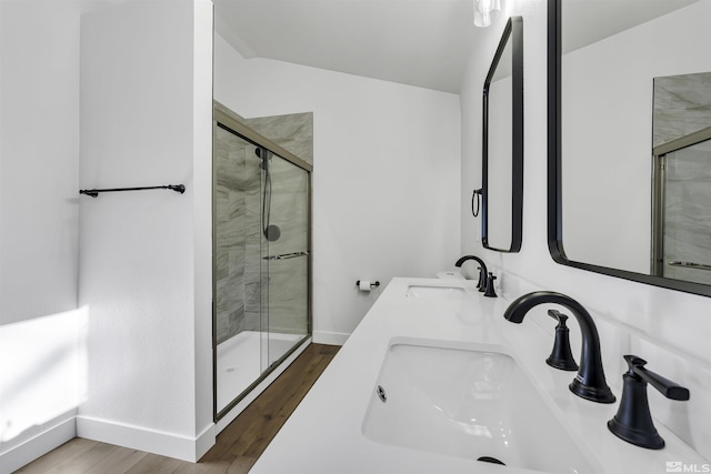 bathroom with vanity, lofted ceiling, hardwood / wood-style flooring, and a shower with door