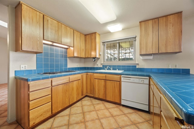 kitchen with white dishwasher, gas cooktop, sink, and tile counters