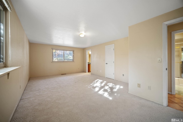 spare room featuring light carpet