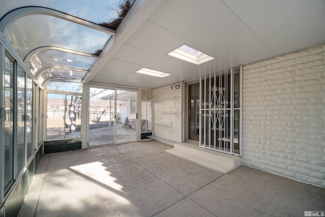 unfurnished sunroom featuring a skylight