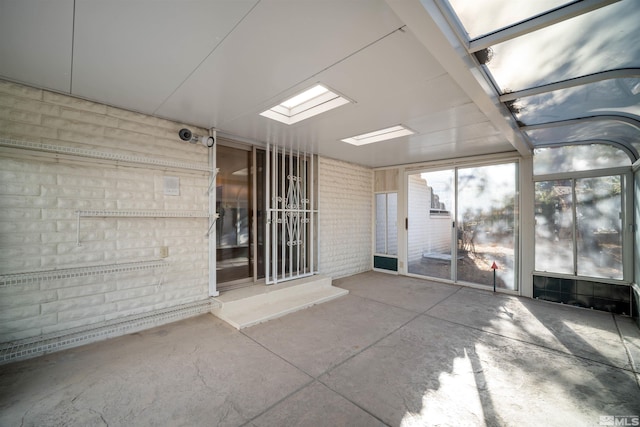 unfurnished sunroom featuring a skylight