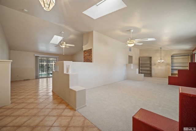 interior space with ceiling fan and vaulted ceiling with skylight